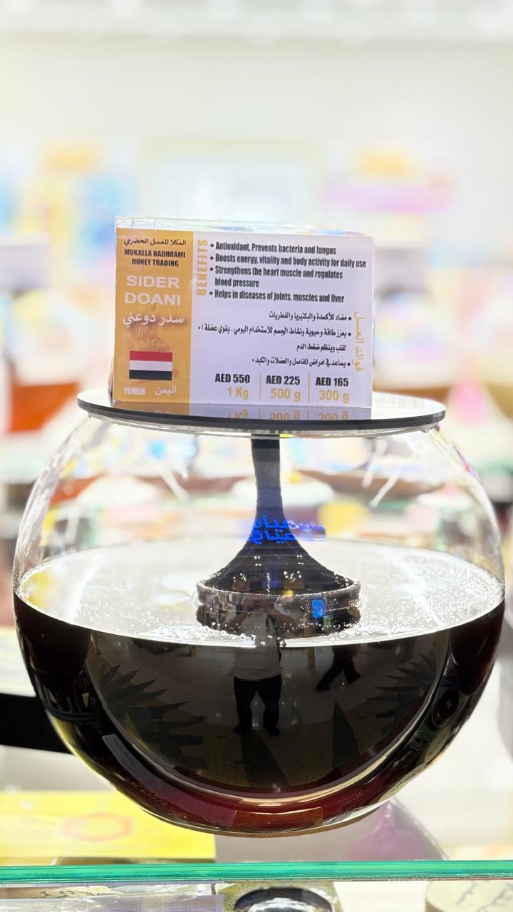 Sider Doani Yemeni honey in a large spherical glass jar with branded label at Mukalla Hadhrami Honey Trading.