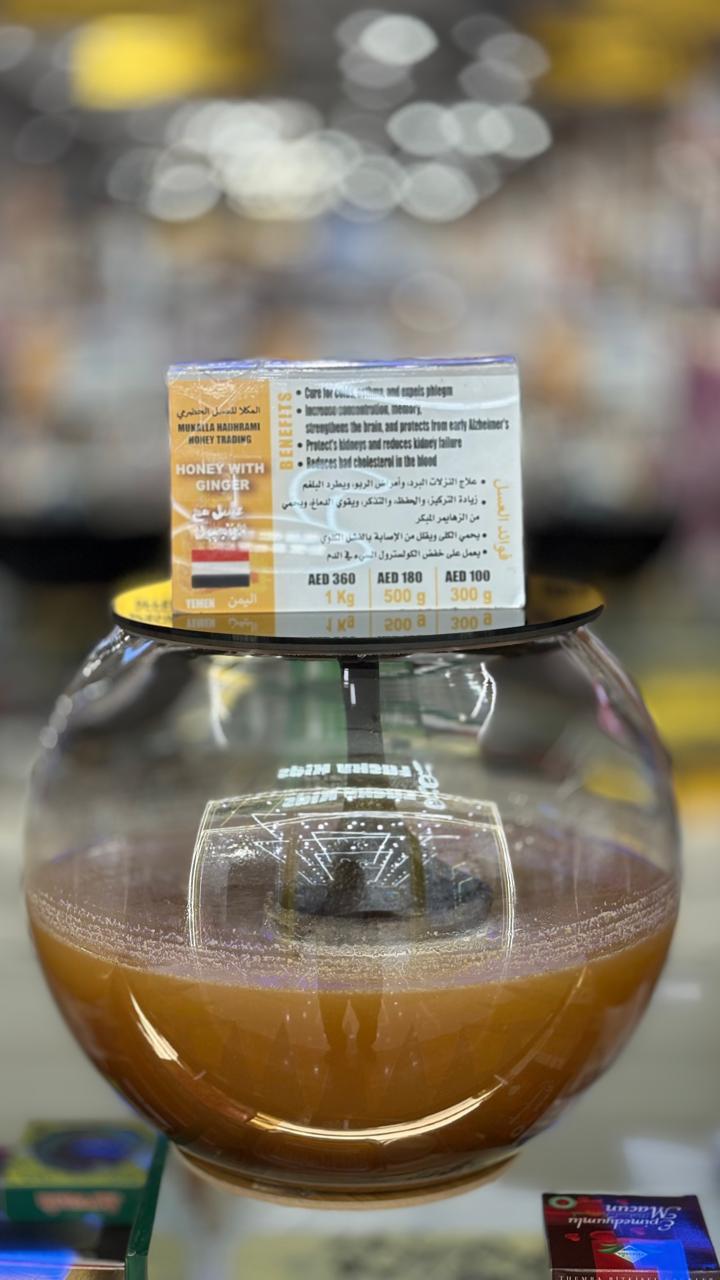 Honey with ginger in a spherical glass jar with branded label.
